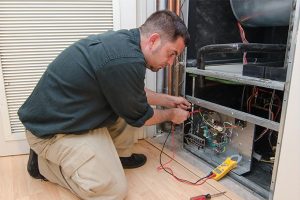 HVAC technician working on HVAC unit in home.