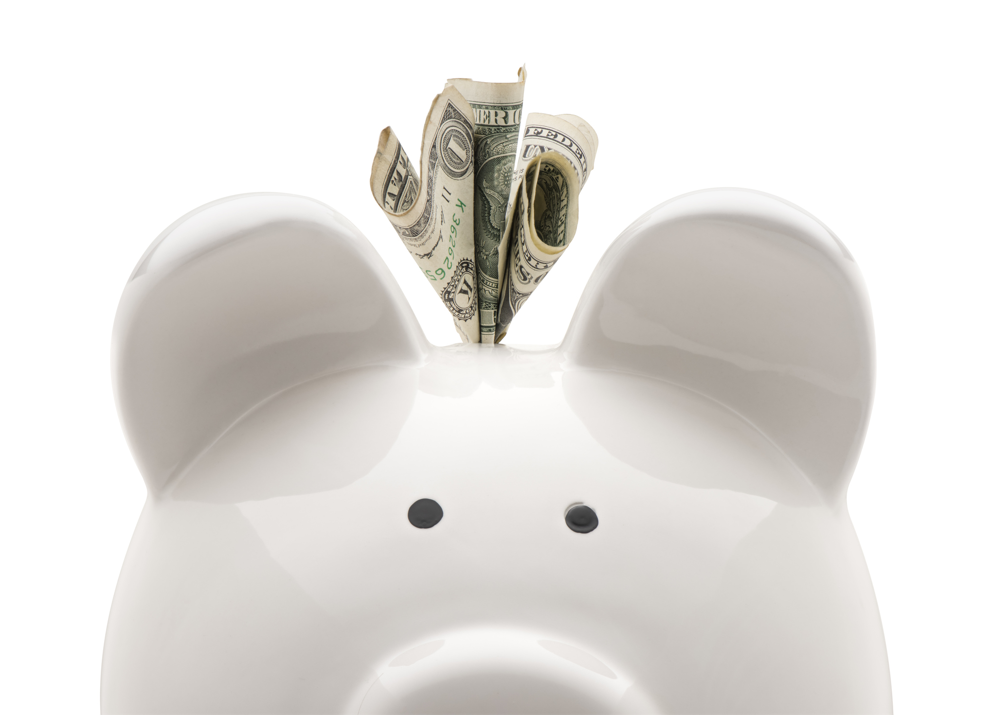 A white piggy bank with money coming out the top of it, against a white background.